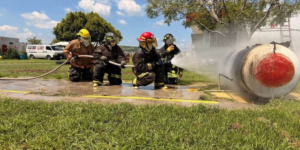Brigada contra incendio en práctica con manguera y fuego real