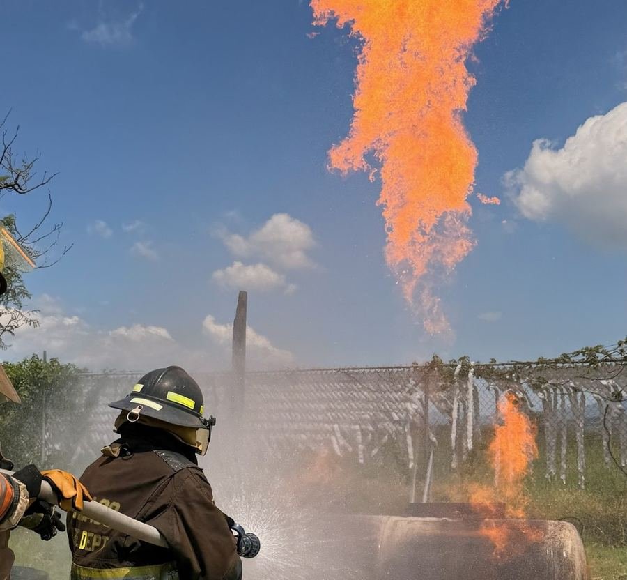 Combate de incendio con fuego real en campo de entrenamiento